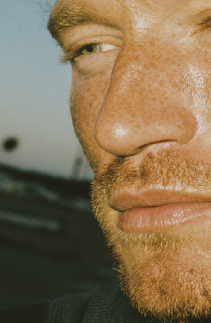 Close up of hand touching bearded face.